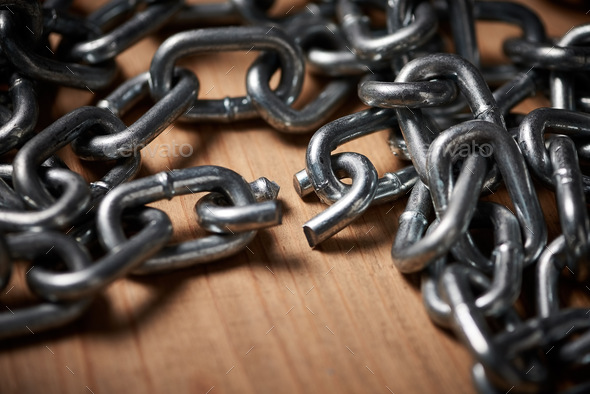 Chains are only as strong as their weakest links. Shot of metal chains with a broken link.