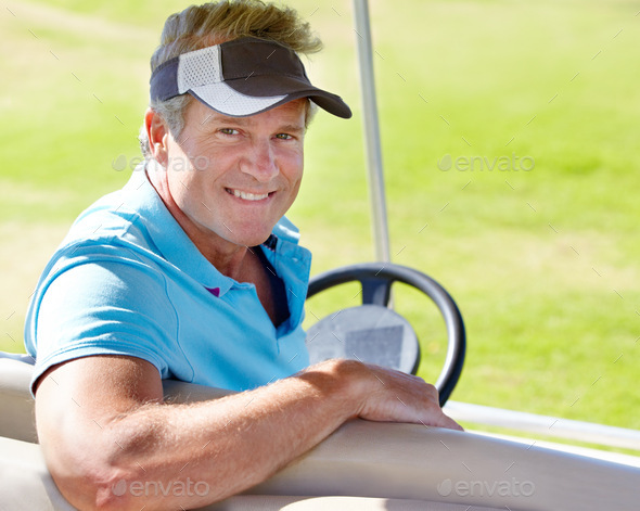 Getting to the next green. Portrait of a smiling mature golfer sitting in a golf car.