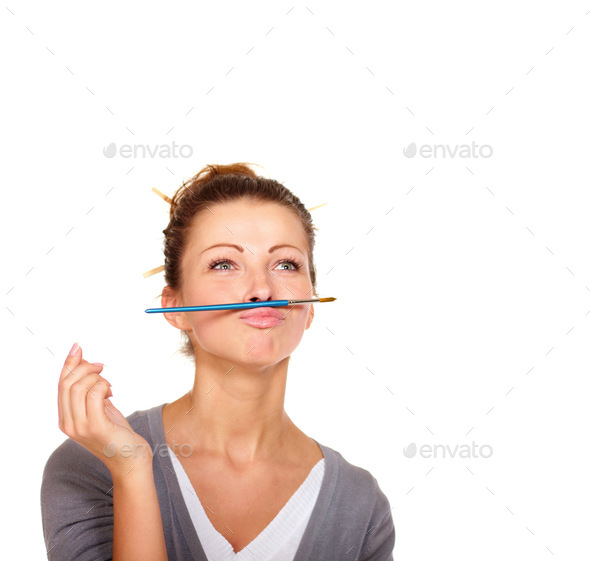 Studio shot of an attractive woman balancing a paint brush on her upper lip