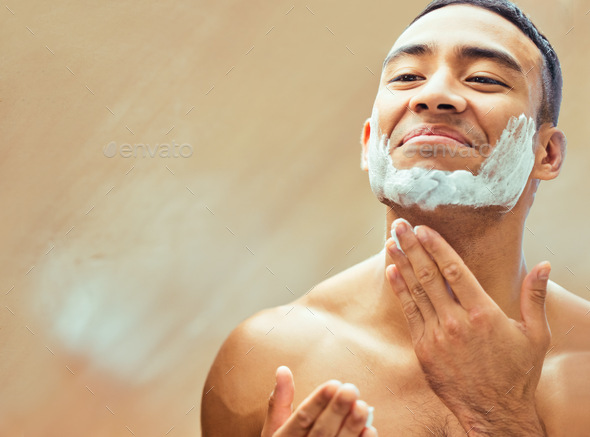 Im ready for a fresh start. Shot of a handsome young man applying shaving cream to his face.