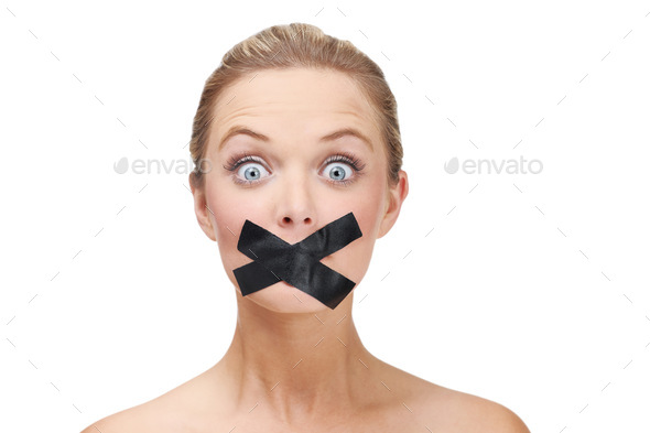 Silenced by the system. A young blonde woman looking shocked with duct tape covering her mouth.