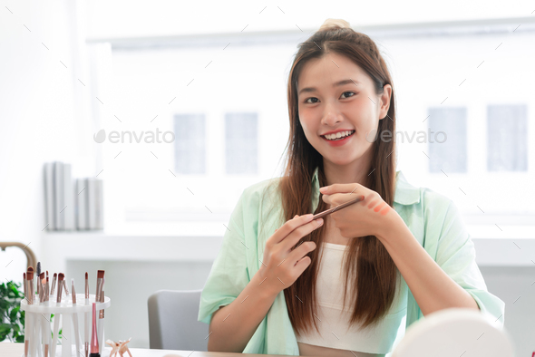 Beauty Vlogger concept, Young woman try eyeshadow on hand to review product while record video Vlog
