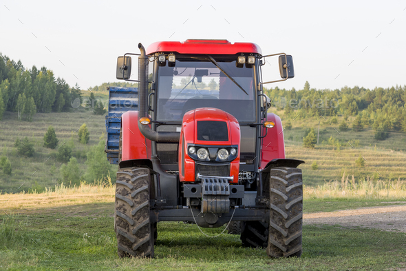 A modern tractor with a sowing machine when planting crops in a rural field  Stock Photo