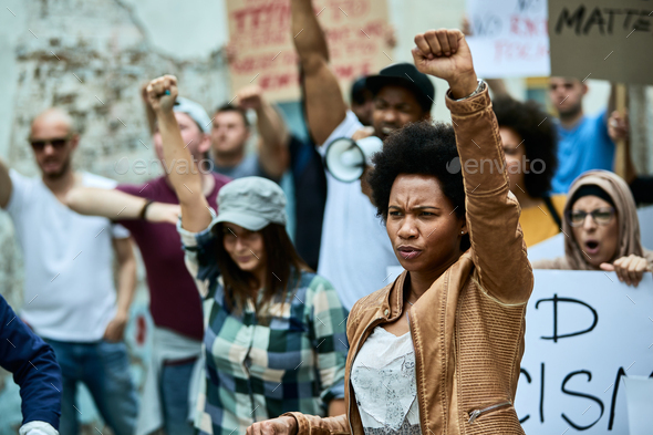 Black woman with raised fist on anti-racism protest.