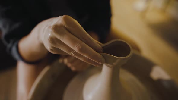 Female Hands of a Potter Sculpt the Spout of an Earthenware Jug From Clay