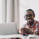 African american man wearing headset communicates with client by video call at laptop. Remote work - PhotoDune Item for Sale