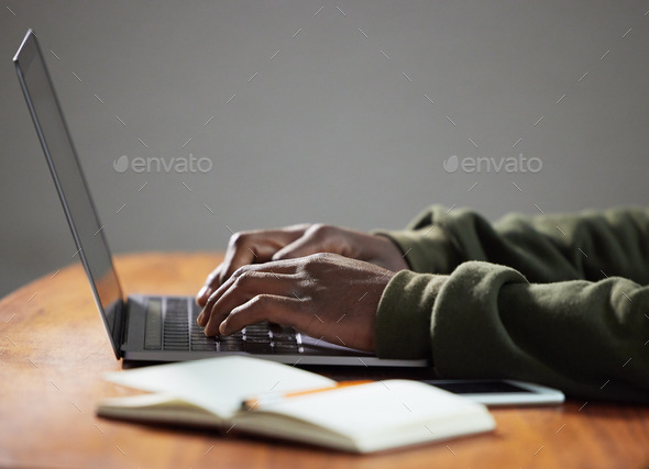 Getting some work done today. Shot of an unrecognizable person using a laptop in an office.