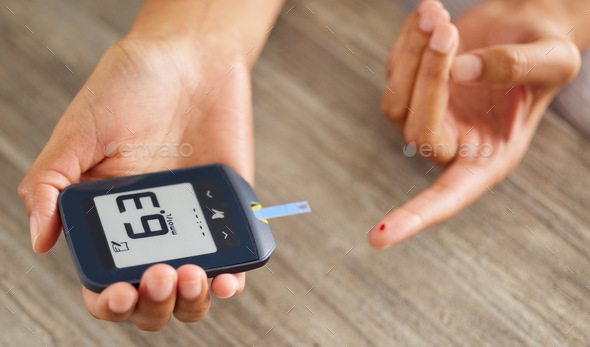 High angle shot of an unrecognizable woman testing her blood sugar level at home