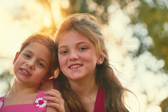 Two sisters, one soul. Portrait of two cute sisters playing together in the park.