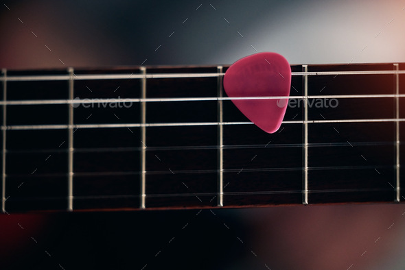 The pick of the bunch. Closeup shot of a guitar pick in between guitar sticks.