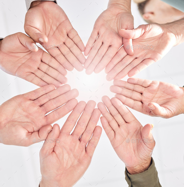 We move as a unit. Shot of a group of business people with their hands together in a circle.