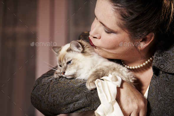 TOO much love, thank you very much. A woman hugging and giving her cat a big kiss.