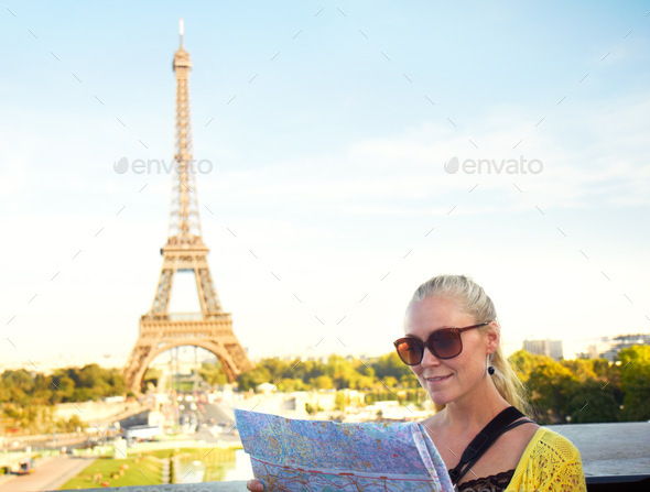 This map is very accurate. A pretty young woman holding a map while sight seeing in the Paris.