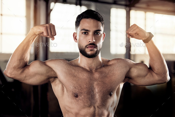 Male Bodybuilder Flexing His Muscle In Gym Stock Photo, Picture