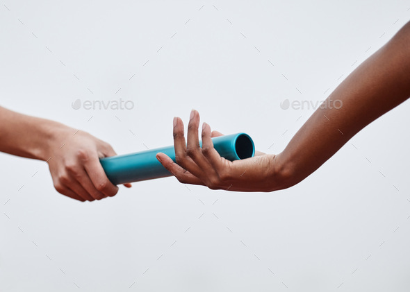 Nothing will stop us now. Shot of two athletes passing a baton during a relay race.