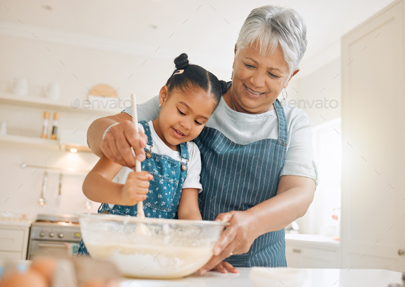 You have to stir it like you mean it. Shot of a little girl baking with her grandmother at home. - Stock Photo - Images