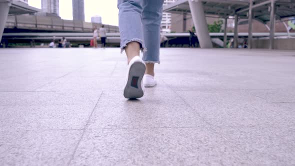 Woman's Feet Walking Through City