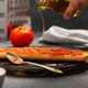 Olive oil is poured on bread, on top of which grated tomato is spread. Spanish traditional breakfast - PhotoDune Item for Sale