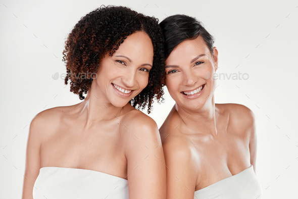 Cropped Portrait Of Two Beautiful Mature Women Posing Against A Grey