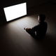 The male sitting in the dark room in front of a white screen - PhotoDune Item for Sale