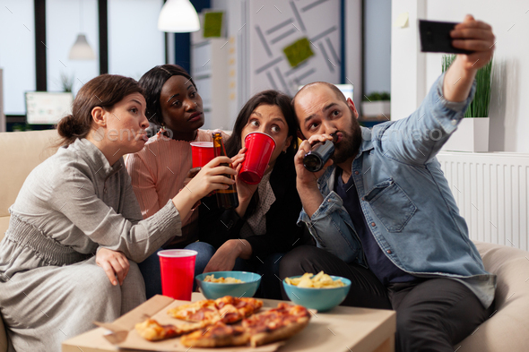 Multi ethnic team of friends make memories at after work party