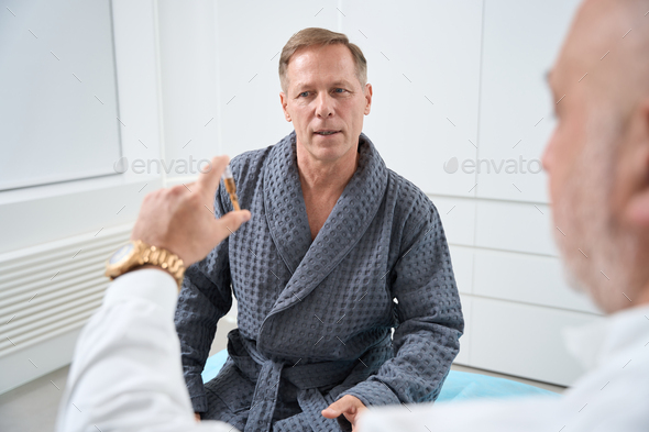 Middle-aged man communicates with a doctor in a medical center