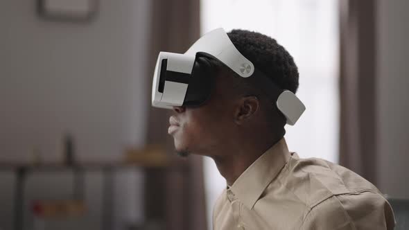 Young Black Man is Enjoying Virtual Reality Viewing 3d Video By Headmounted Display Vr Glasses for alt
