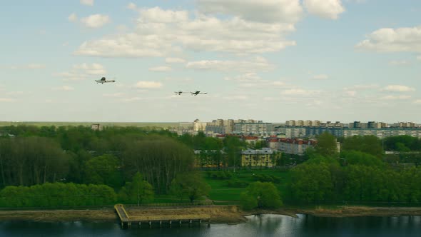 A Group of Three Propeller Planes Fly Over the Bridge and Fly in Different Directions on a Sunny alt