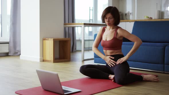Woman Practicing Yoga with Trainer Via Video Conference Warming Up Joints alt