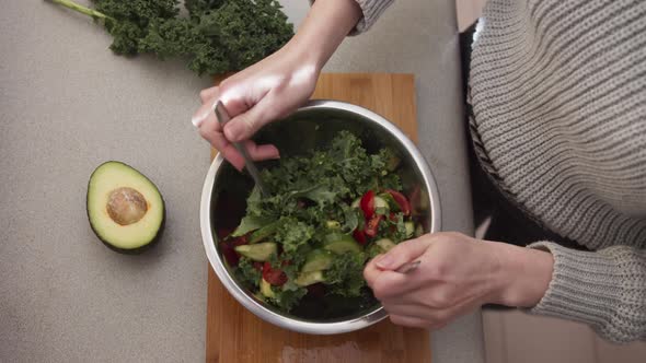 Female Hands Mixing Vegetable Salad in A Salad Bowl