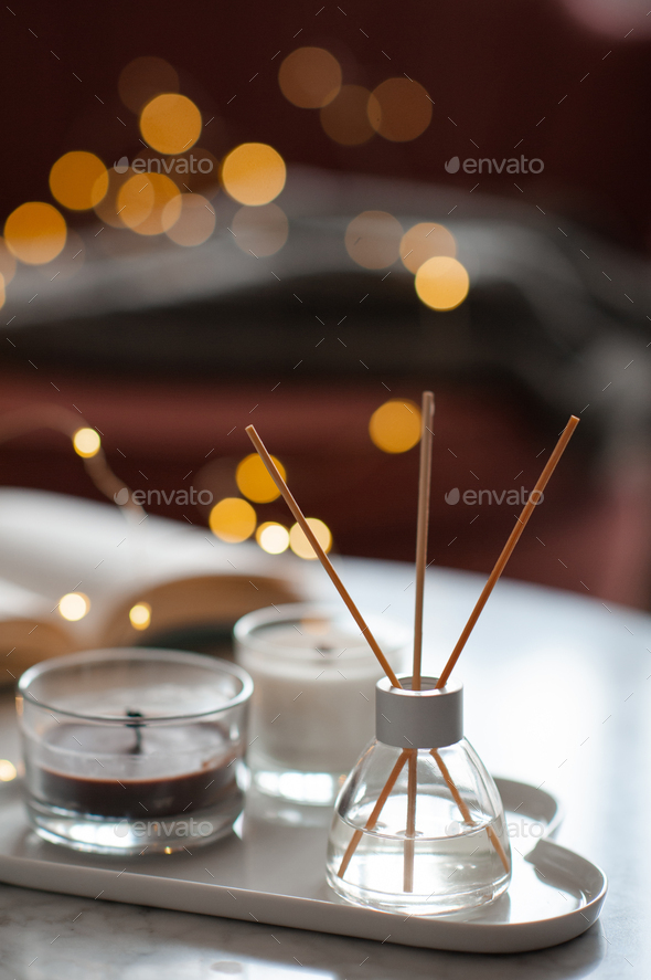 Organic soy wax candle with home diffuser in room over light Stock Photo by  morrowlight