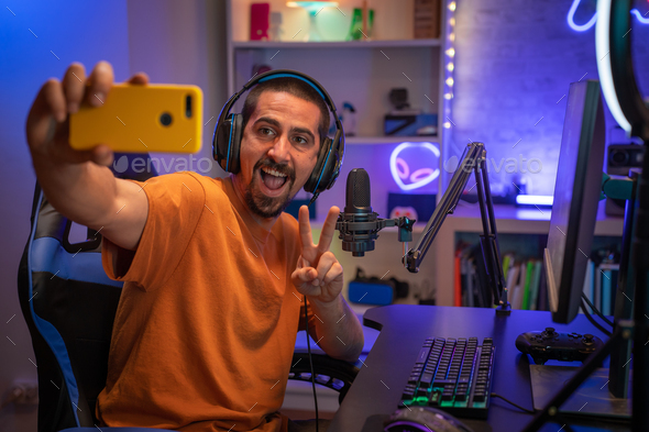 Gamer taking a selfie in gaming room playing online streaming games