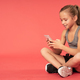 Adorable girl using cellphone against red background - PhotoDune Item for Sale