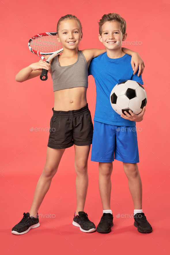 Adorable sporty kids standing against red background - Stock Photo - Images