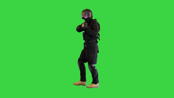 Armed Police Officer Aiming and Shooting with a Pistol While Walking on a Green Screen Chroma Key alt