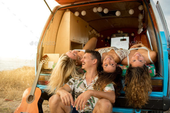 Man with three women having fun inside a van Stock Photo by riderfoot