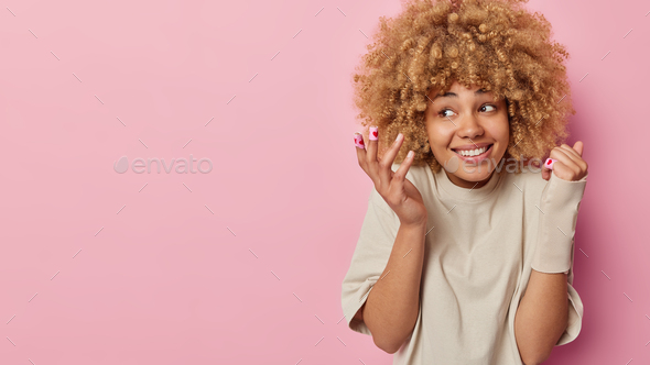 Happy curly haired woman applies medical adhesive plaster for treatment of injuries cuts on skin