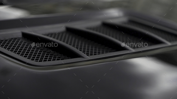 Close up for detail of air vents on the bonnet of a modern black car.  Stock. Car exterior background Stock Photo by BlackWhaleMedia