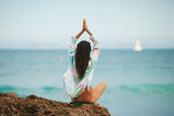 Young woman with practicing yoga on the beach - Stock Photo - Images