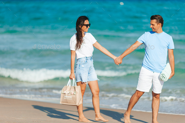 Young couple in love on the beach summer vacation. Happy man and woman enjoy time together - Stock Photo - Images