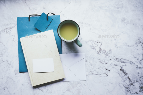 Mockup as a clean flat lay desktop with a business card, notbook and a bag