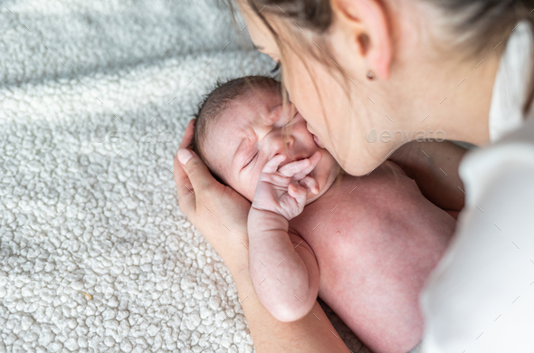 Mom calms and hugs her newborn child - Stock Photo - Images