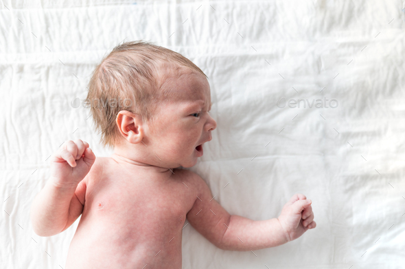 Newborn baby laying on changing table - Stock Photo - Images