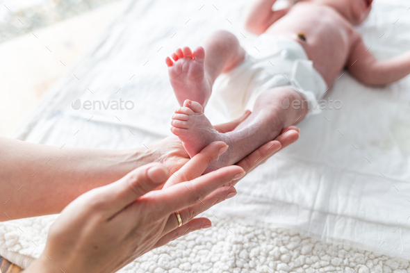 Mother using cream on body of newborn baby - Stock Photo - Images