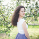 Cheerful young woman in a white t-shirt under the blooming tree. - PhotoDune Item for Sale