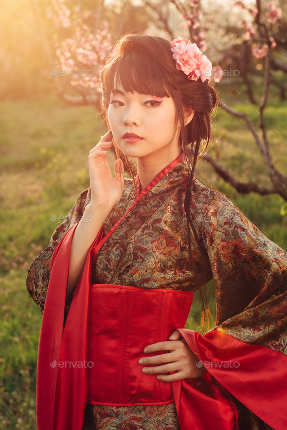 Portrait of beautiful asian woman in blooming park at sunset - Stock Photo - Images