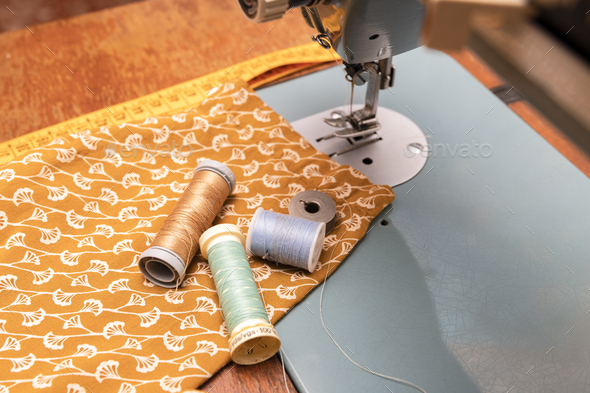couturier material with foreground thread reels, tape measure