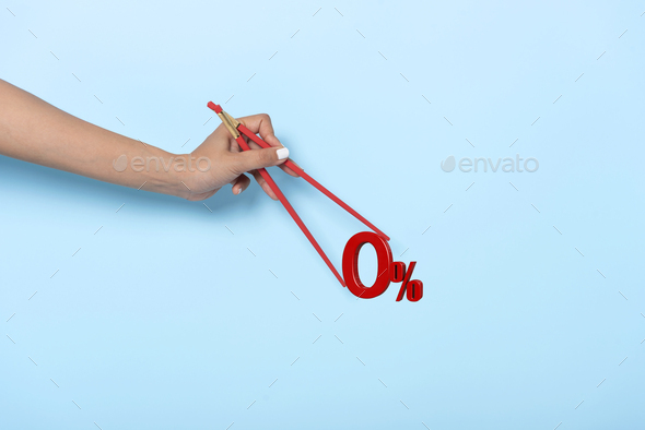 Woman hand holding chopsticks showing 0% number or zero percent isolated on blue banner background.  - Stock Photo - Images