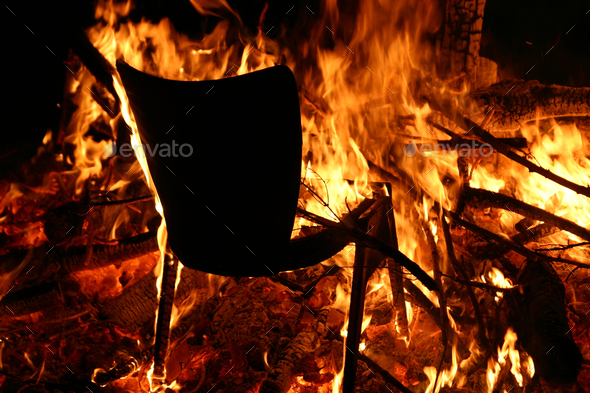 Black chair on fire with everything else burning next to it - horror concept
