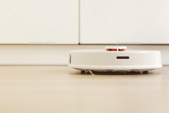 white robotic vacuum cleaner. The robot is controlled by voice commands for direct cleaning. Modern
